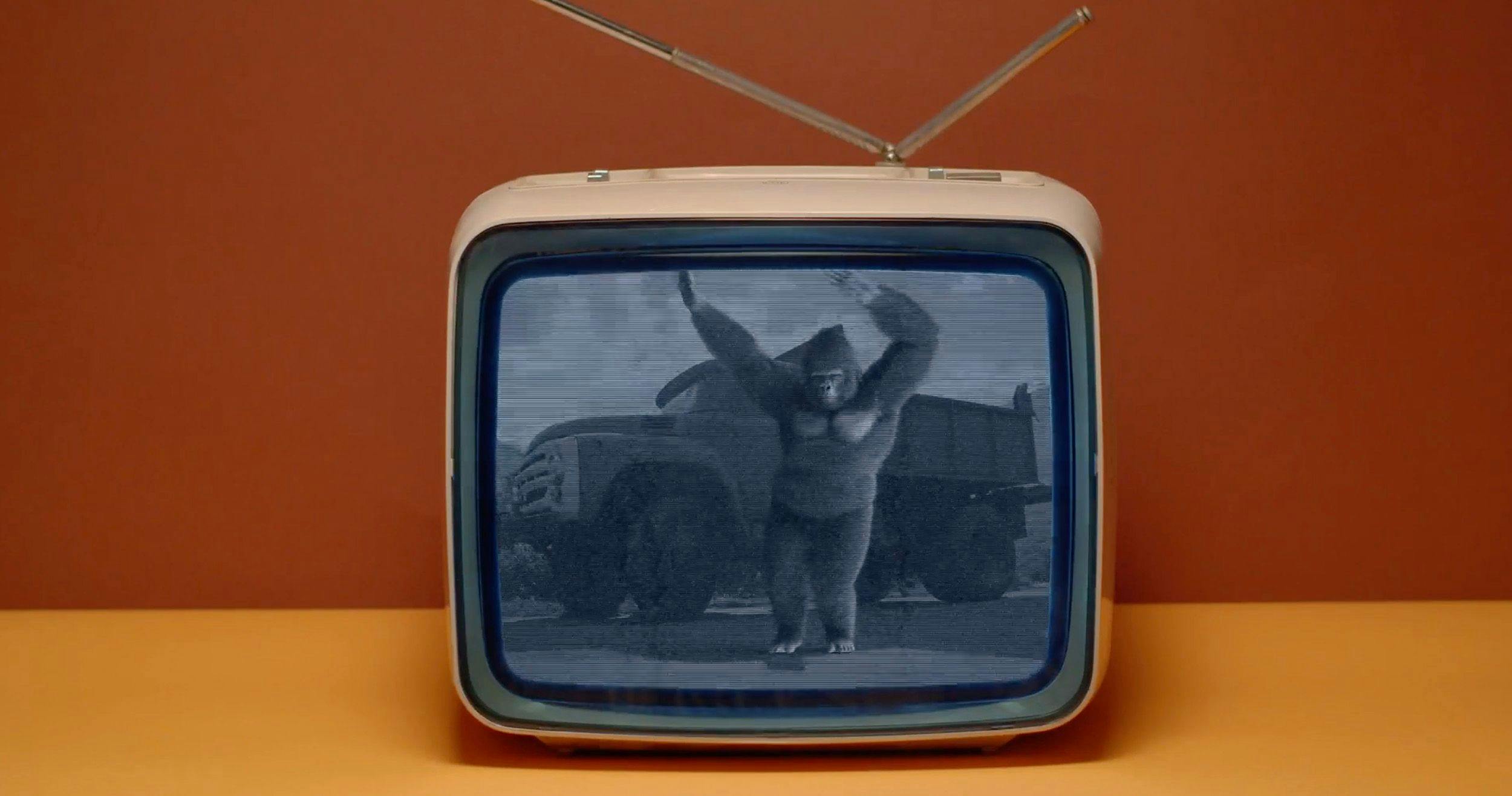 Gorilla dancing in front of a retro truck on an old-school TV.