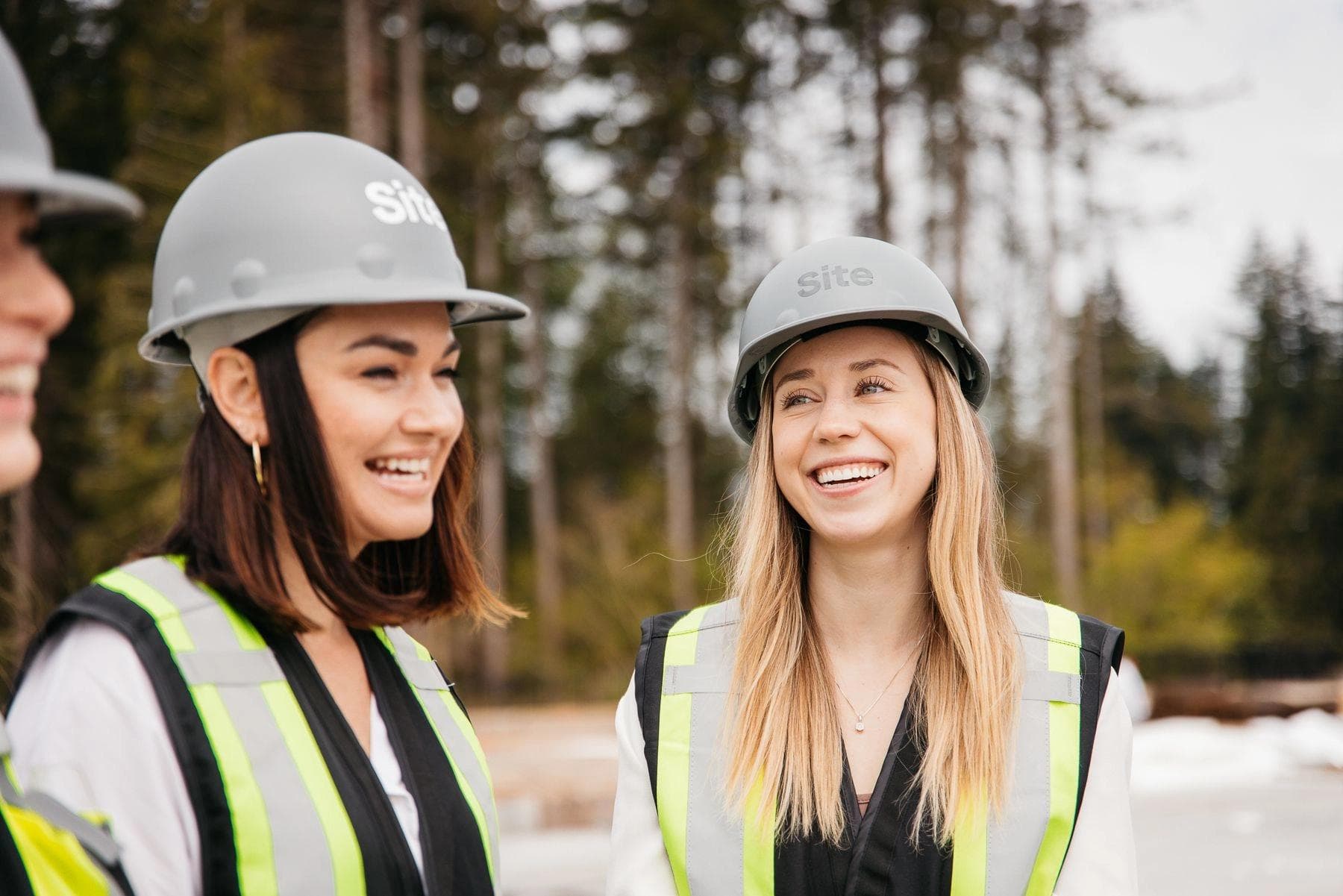 Two women from the Site team wearing hard hats and safety vests